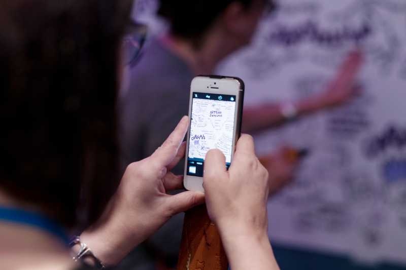 Woman using a smart-phone to take a photo for social media