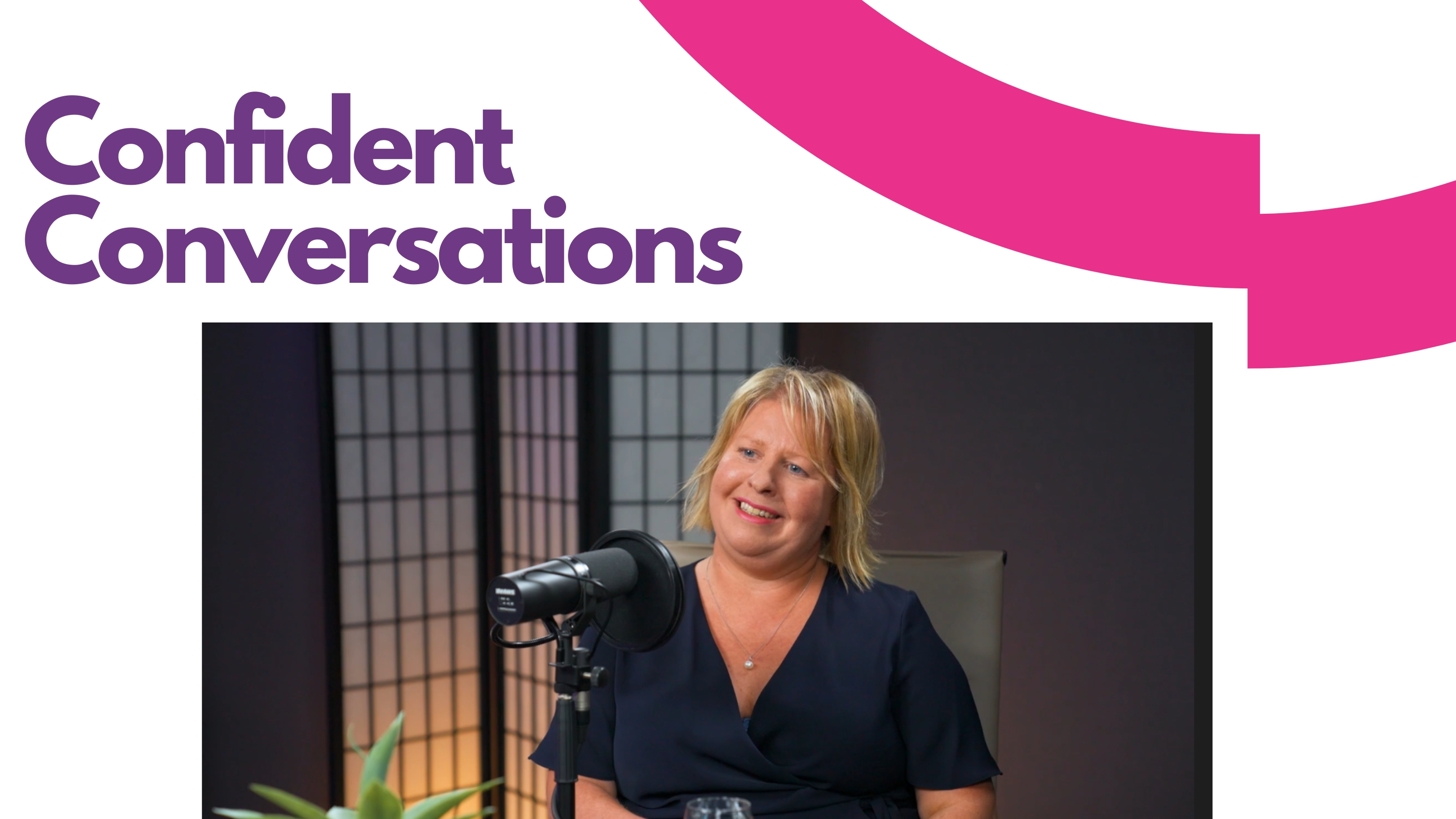 Still from episode, showing Kate interviewing Leanne. They sit opposite each other at a table in a studio setting, with professional microphones in front of them.