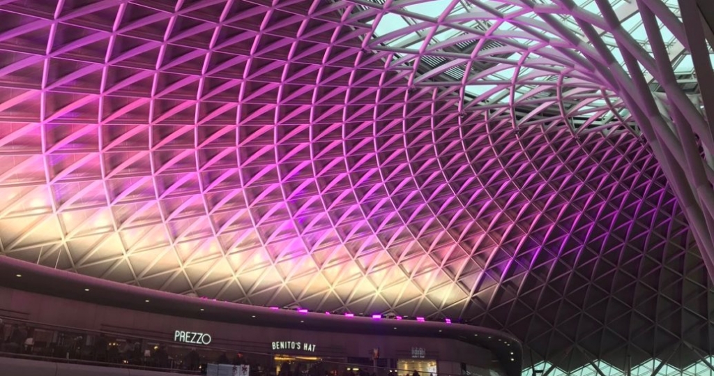 Roof of Kings Cross station lit up purple