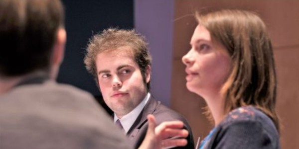 Image of a male and a female member sat a table at one of our in-person events, in discussion